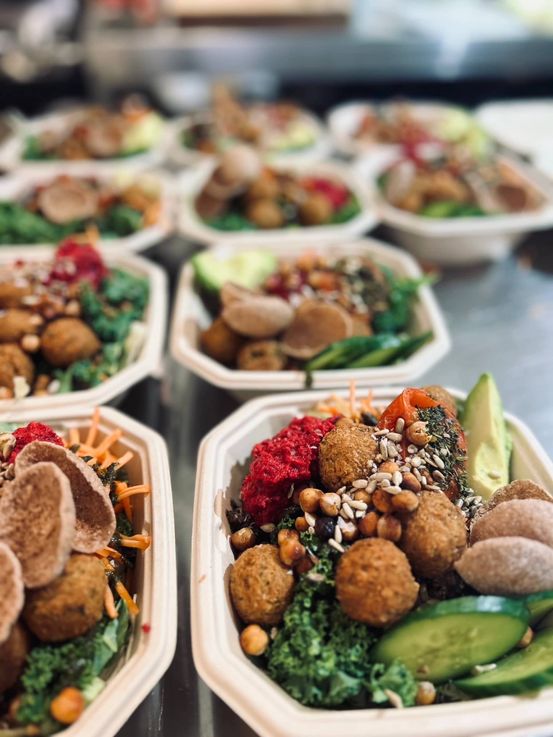 Färgglada bowls med falafel, grönsaker och röror