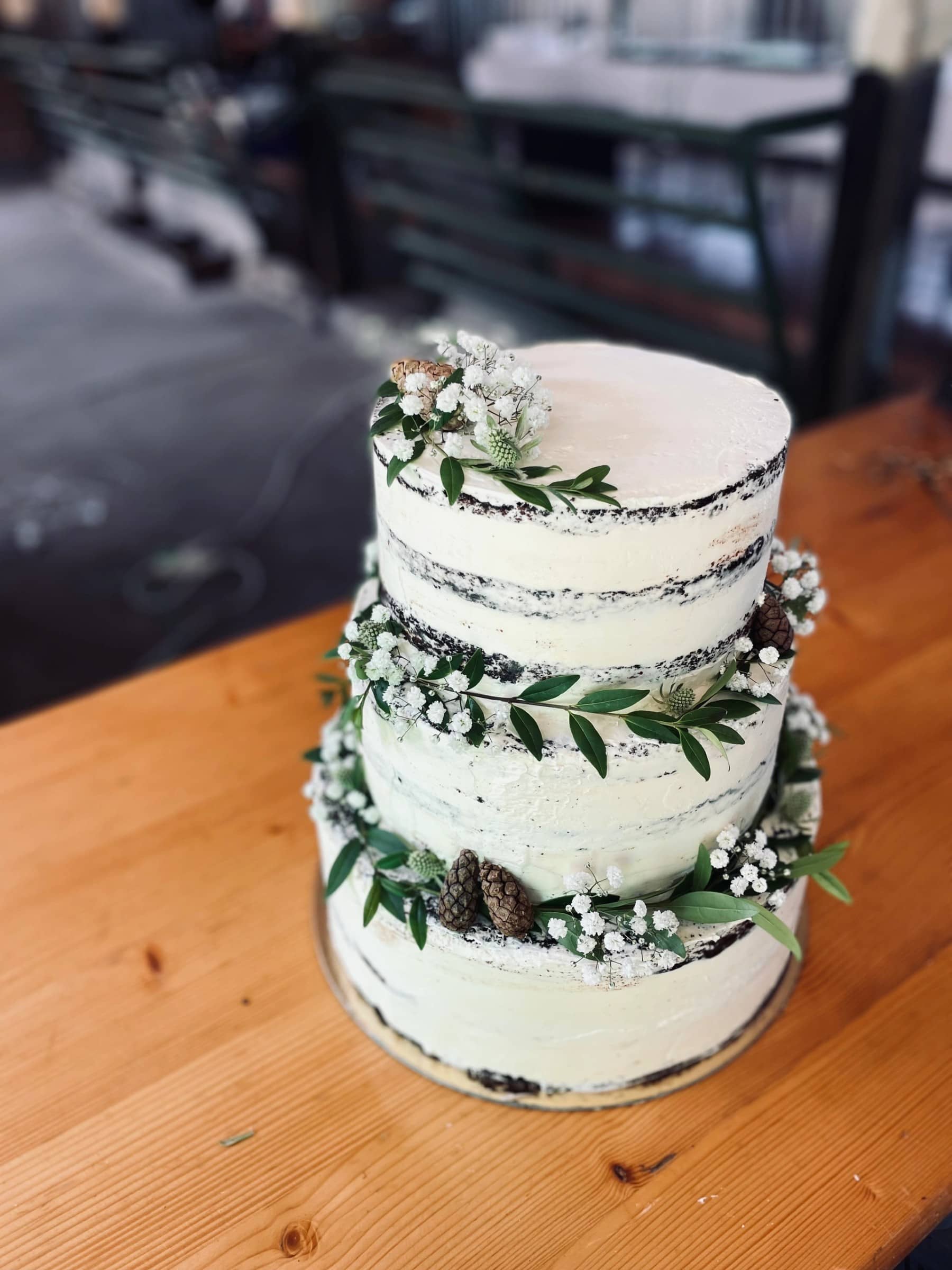 Bröllopstårta med blommor och grön dekoration
